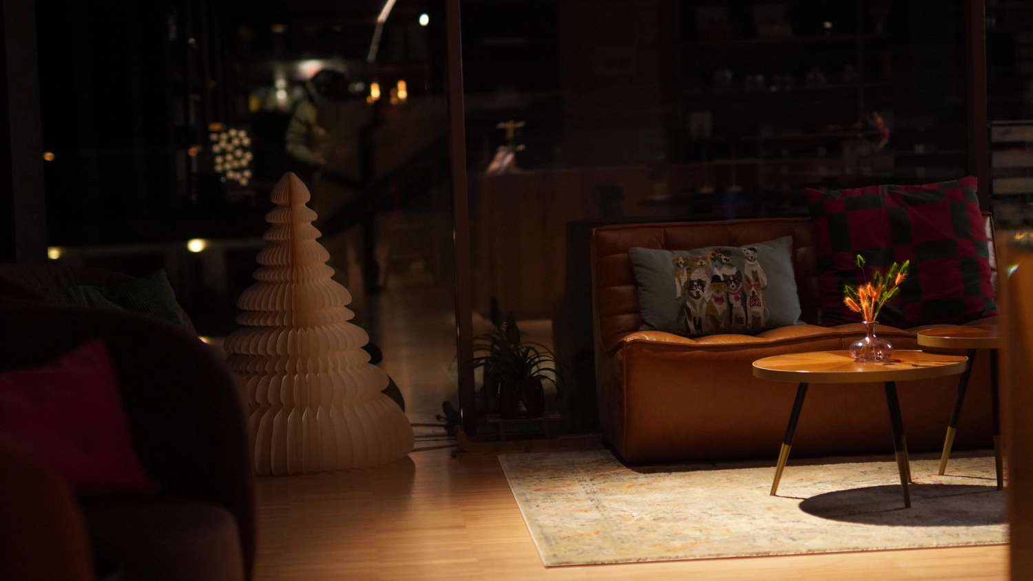 Sipho Studio - Drone visuel - Gemütliches Wohnzimmer mit braunem Ledersofa, zwei Holztischen und warmen Deko-Details